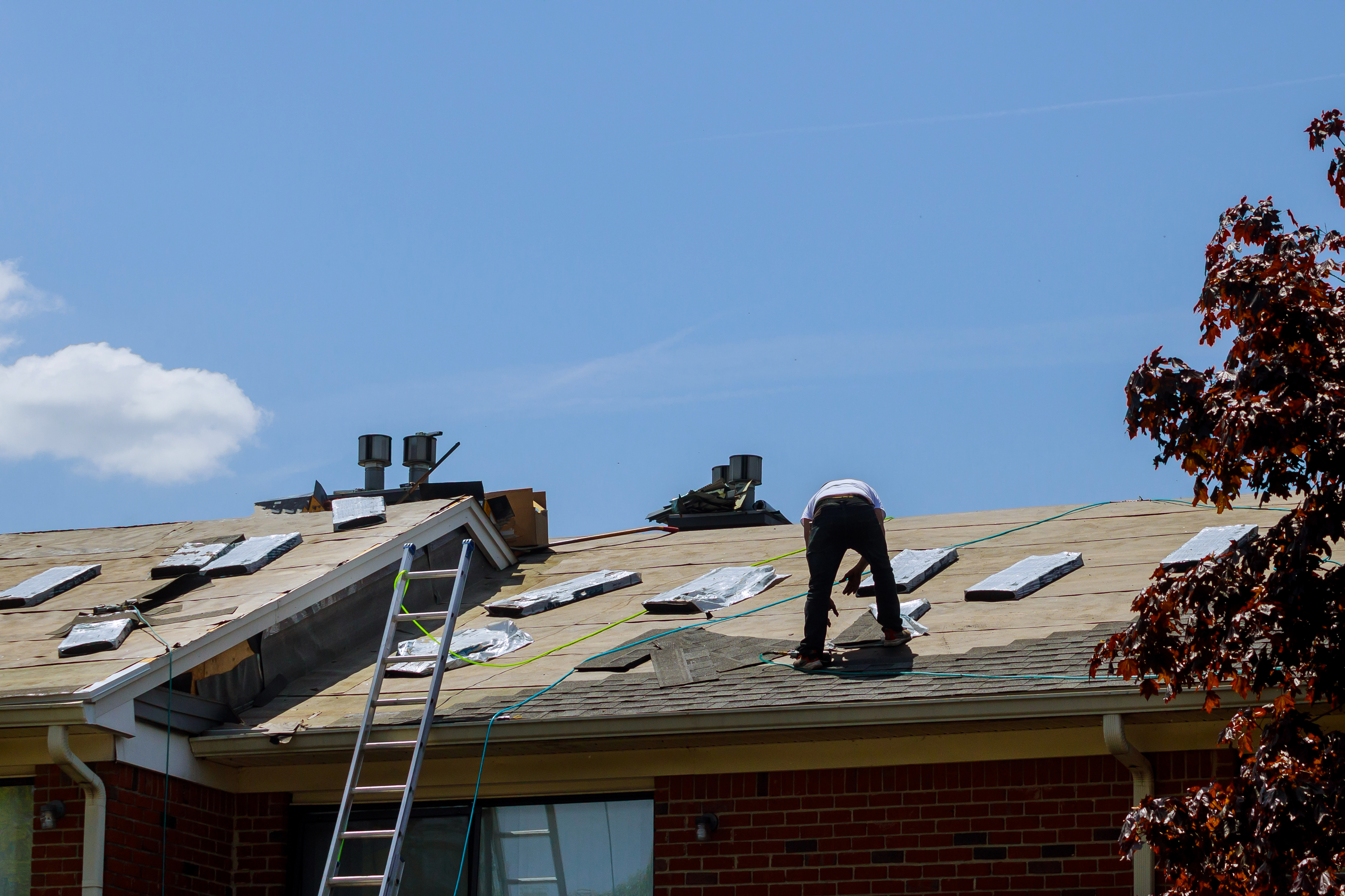 Roofer working on tear-off and replacement